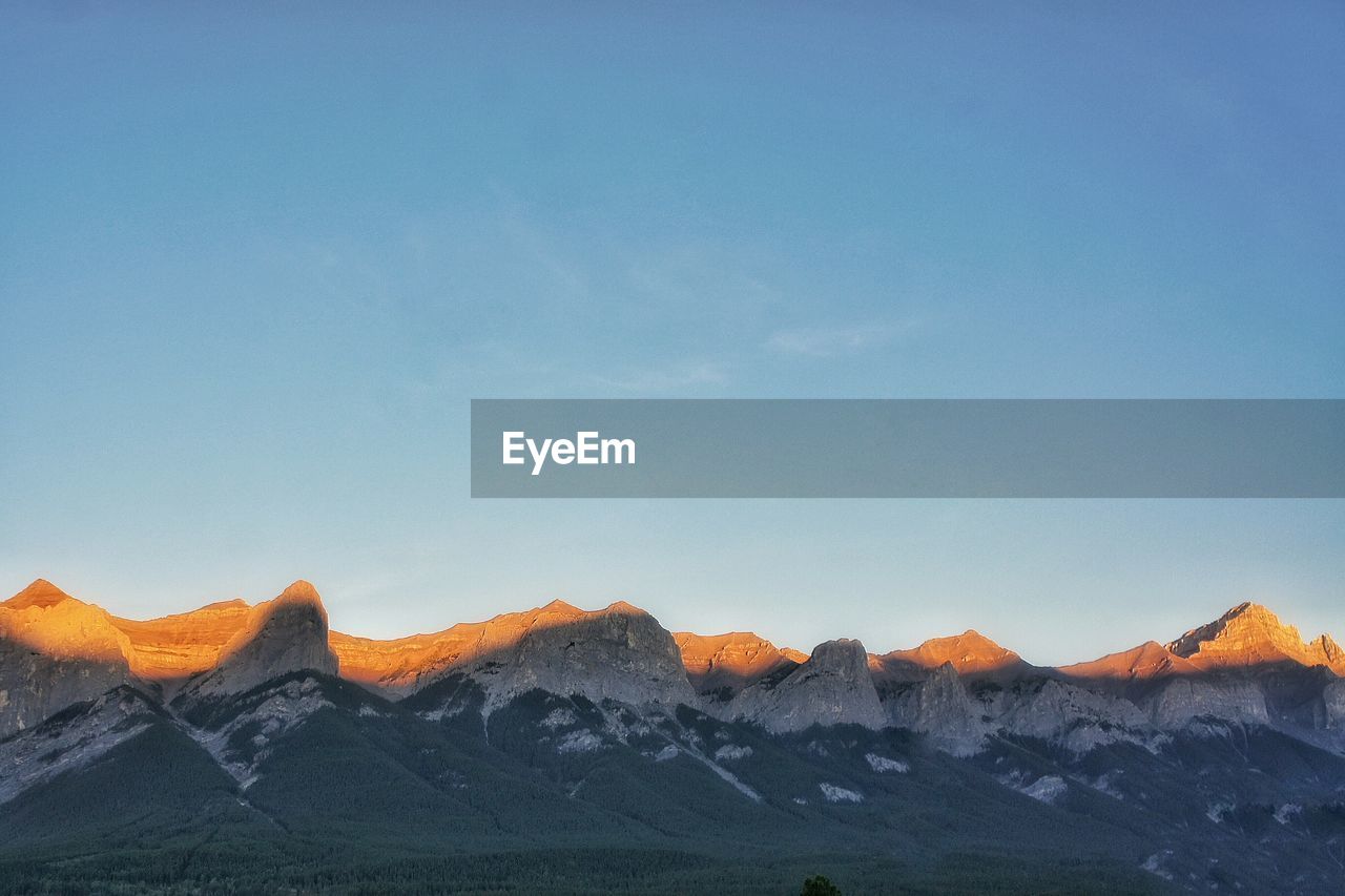 Scenic view of mountains against clear blue sky