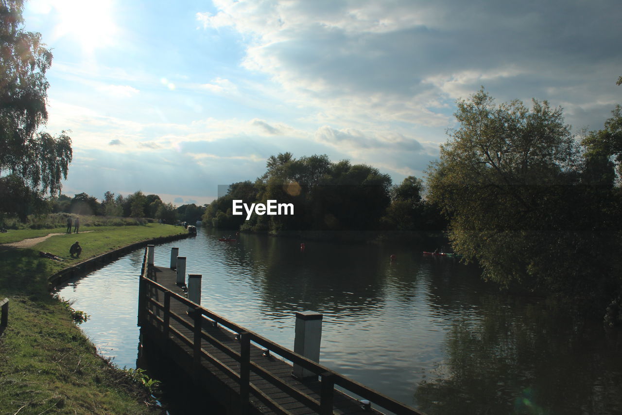 VIEW OF CALM RIVER AGAINST CLOUDY SKY