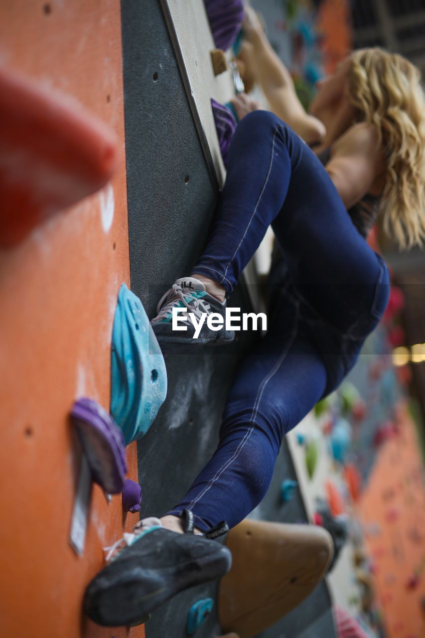 Low angle view of female athlete climbing wall