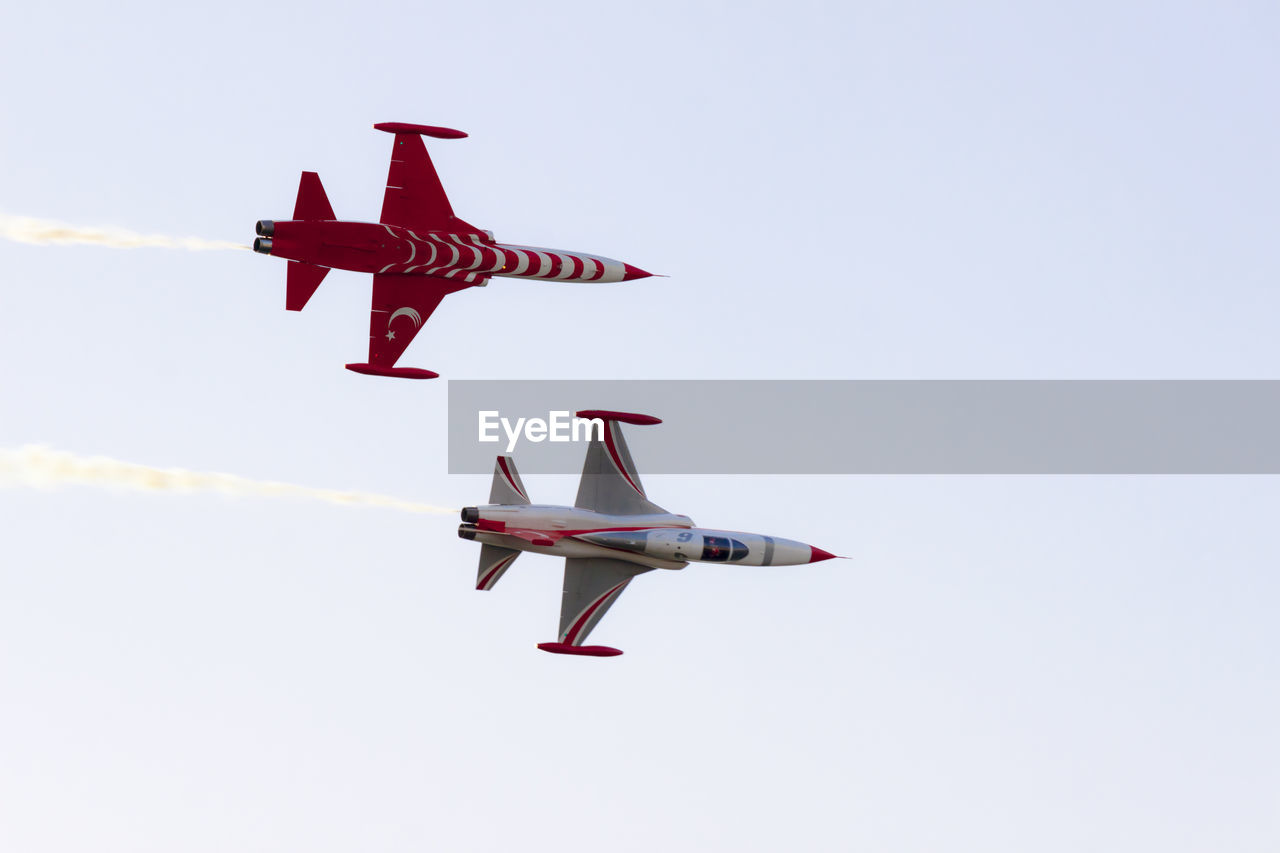 LOW ANGLE VIEW OF AIRSHOW AGAINST SKY