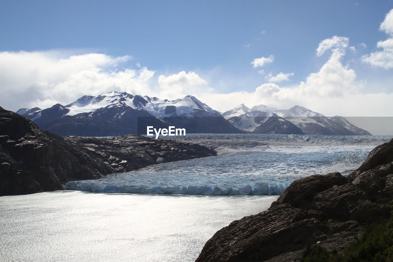 High angle view of river and snowcapped mountains against sky