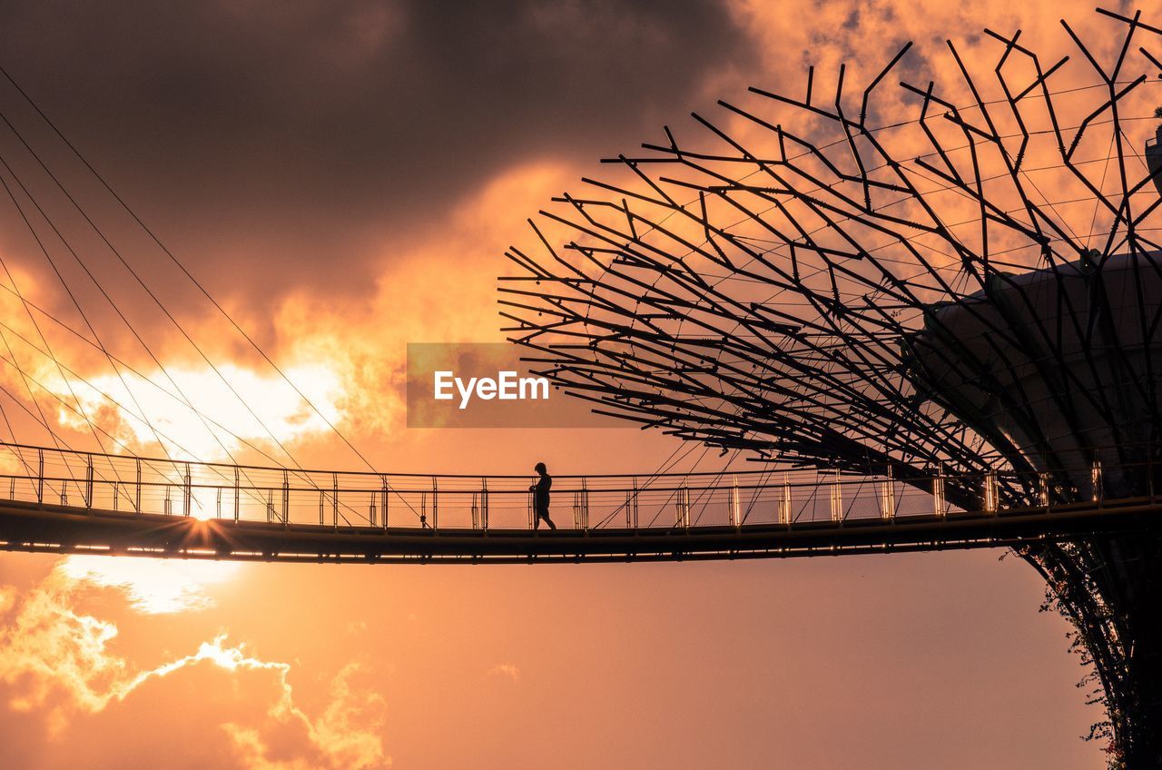 LOW ANGLE VIEW OF SILHOUETTE BRIDGE AGAINST ORANGE SKY