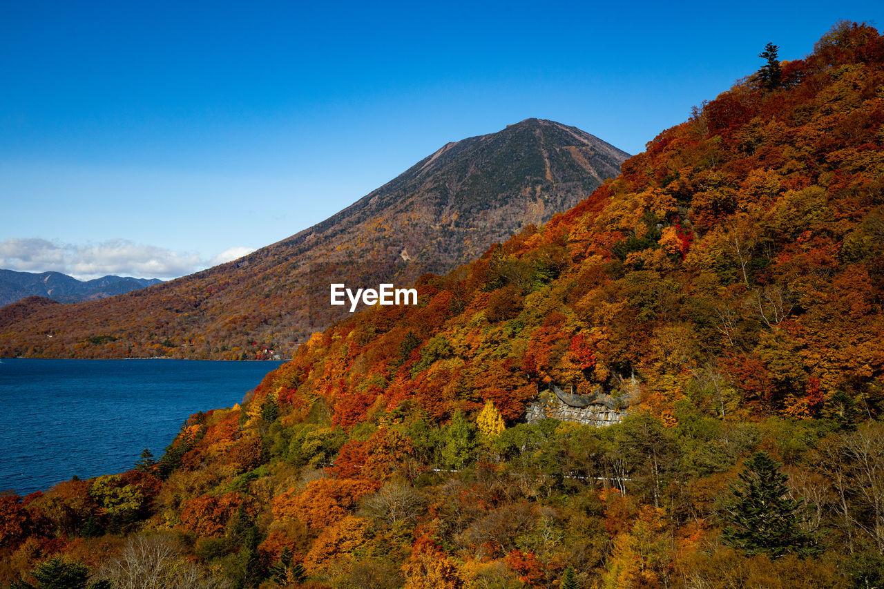 Scenic view of lake chuzenji against sky during autumn