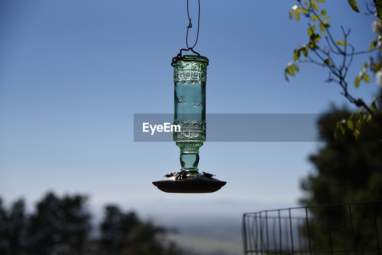 Close-up of bird feeder hanging against clear sky