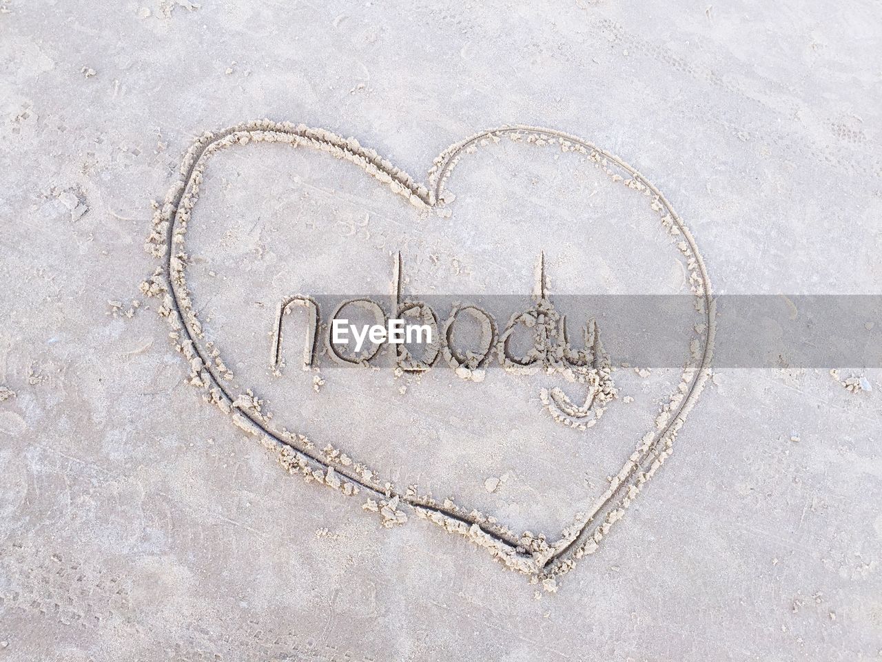 High angle view of text amidst heart shape on sandy beach