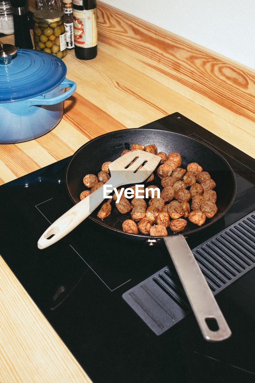 High angle view of meatballs in pan over ceramic stove top at home