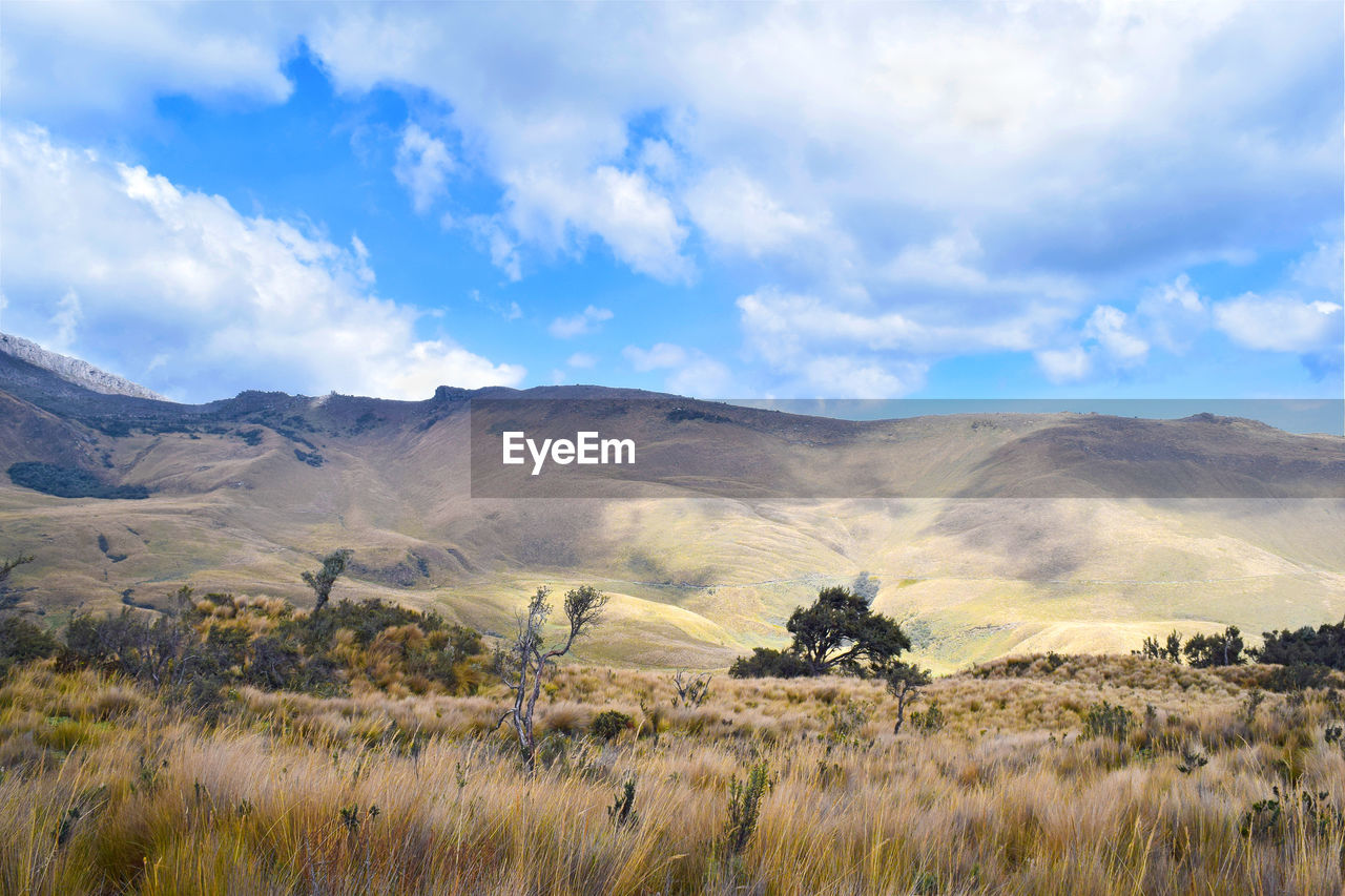 Scenic view of mountain range against cloudy sky