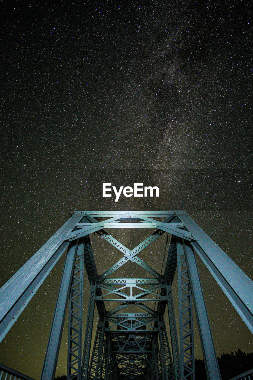 low angle view of bridge over river against sky at night