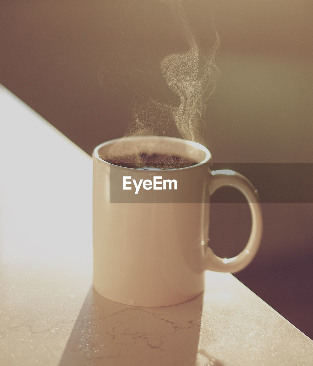 CLOSE-UP OF COFFEE CUP WITH SPOON ON TABLE