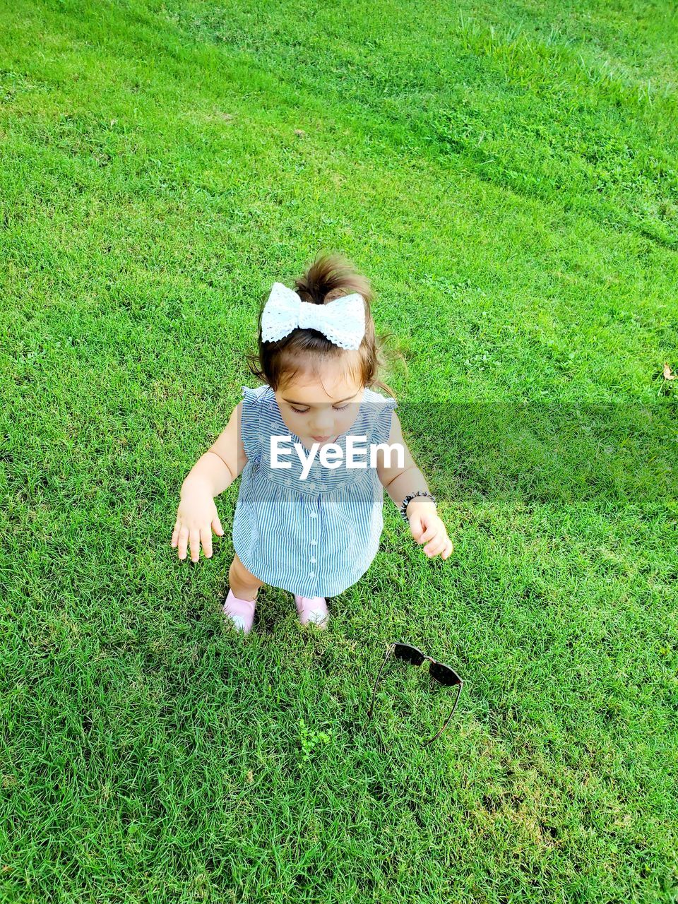 HIGH ANGLE VIEW OF CUTE GIRL ON GRASS