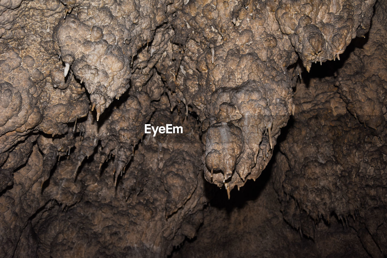 Close-up of rock formation in cave, stalactites in cave