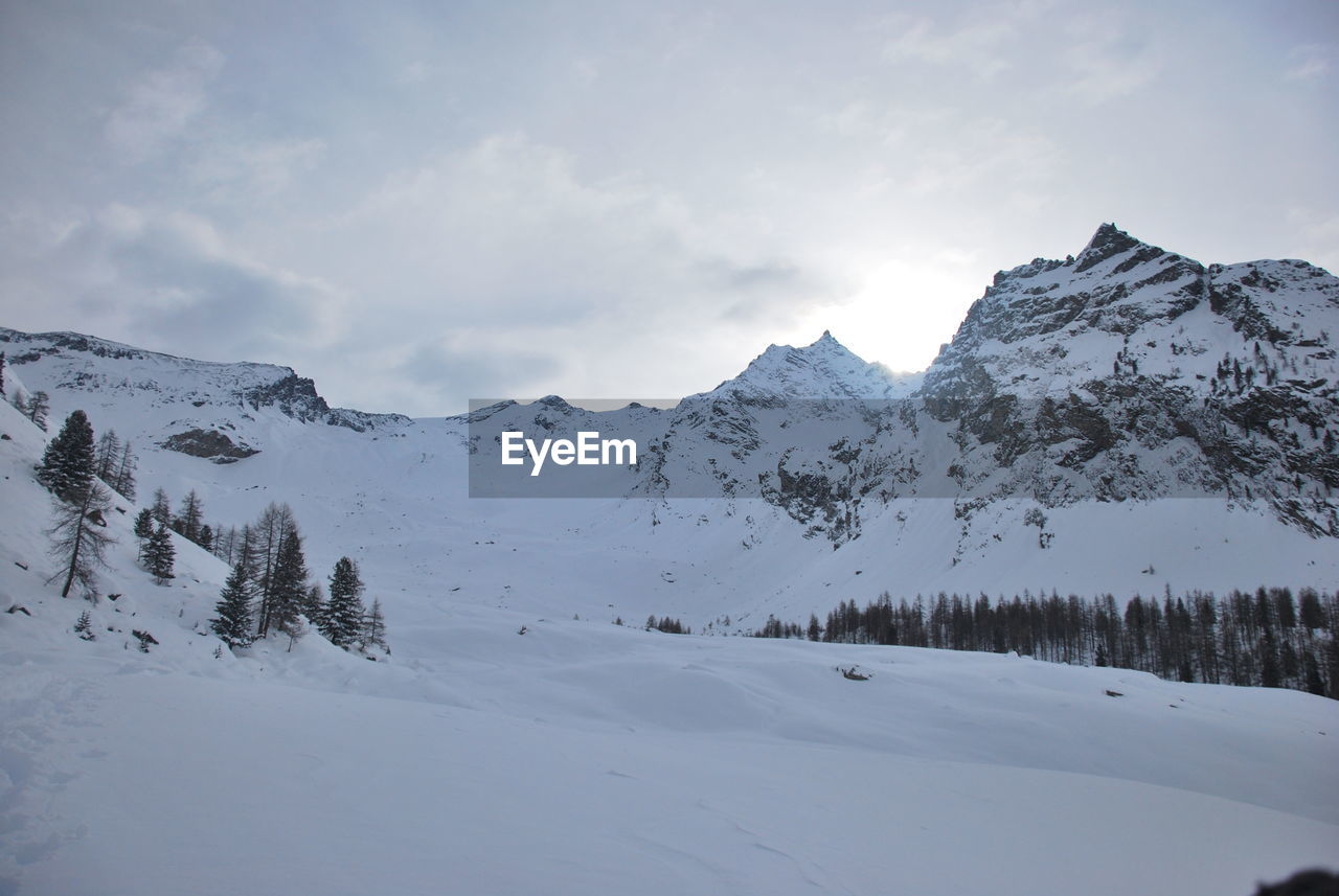 Scenic view of snow covered mountains against sky