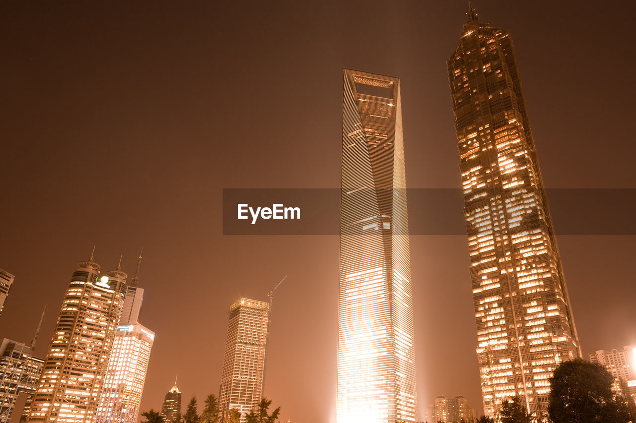 Low angle view of illuminated skyscrapers against sky at night