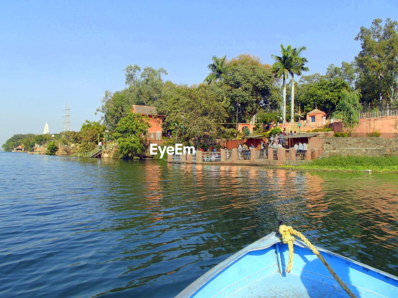 PEOPLE ON LAKE AGAINST TREES