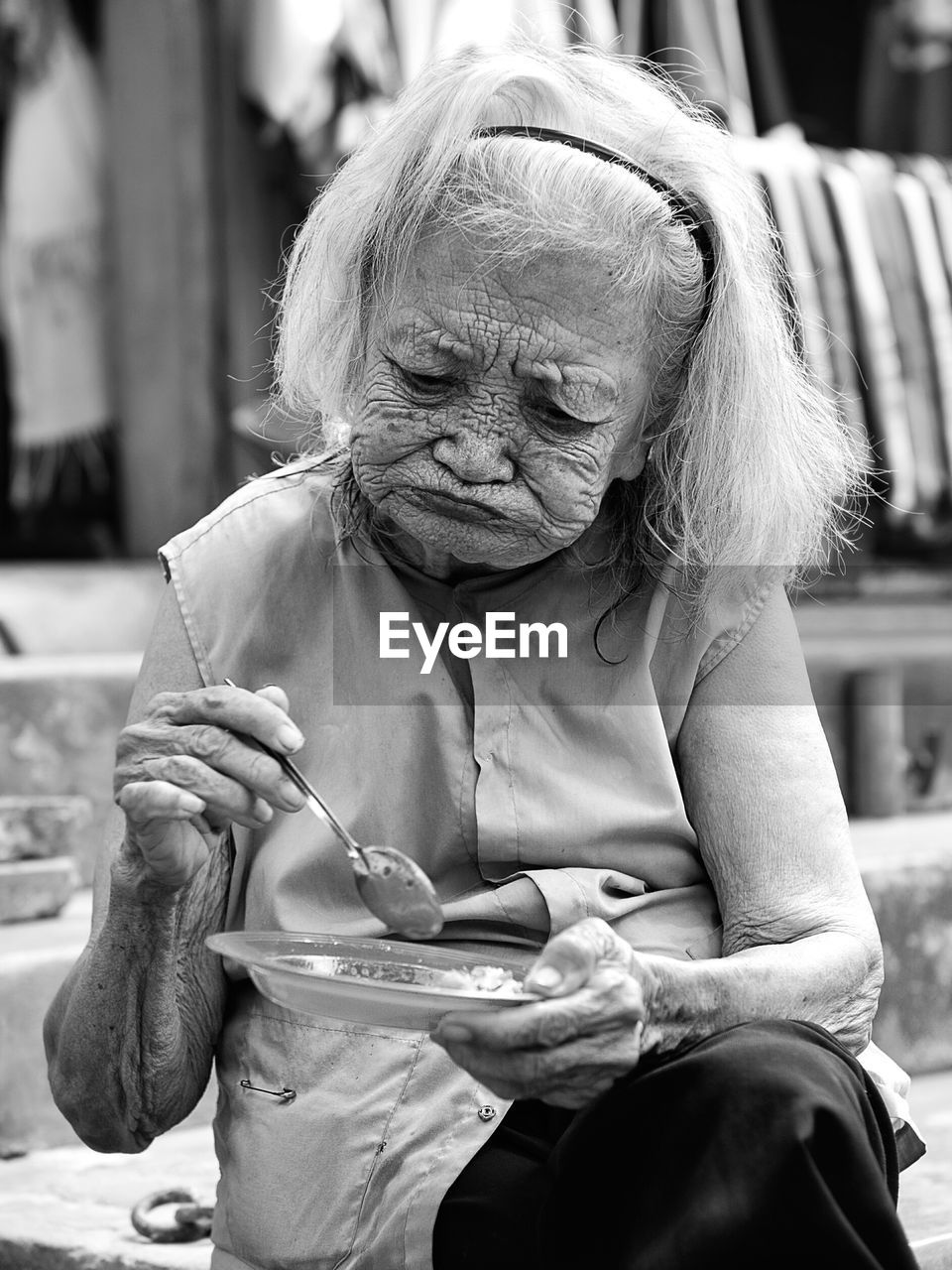 Senior woman eating while sitting outdoors