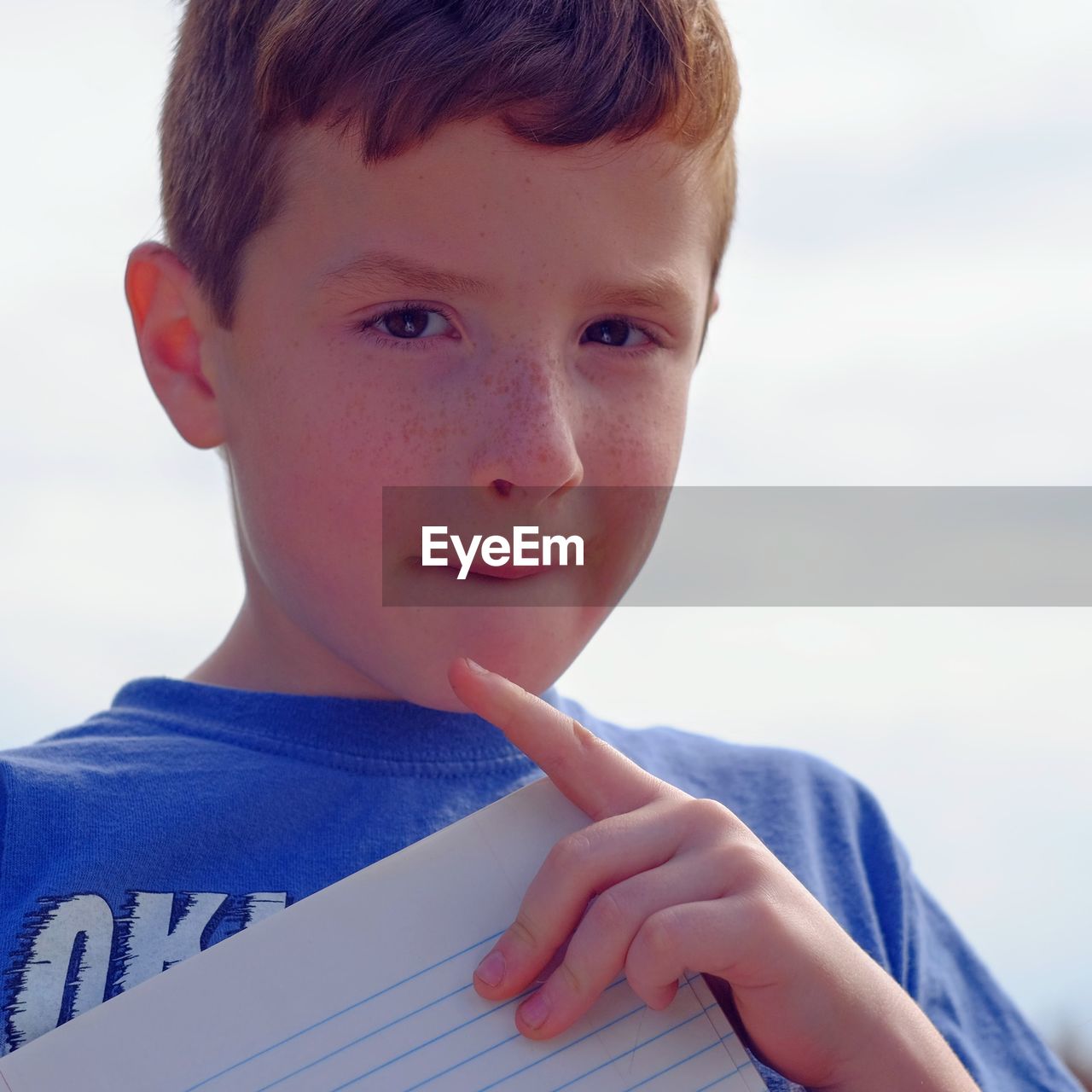 Close-up portrait of boy against sky