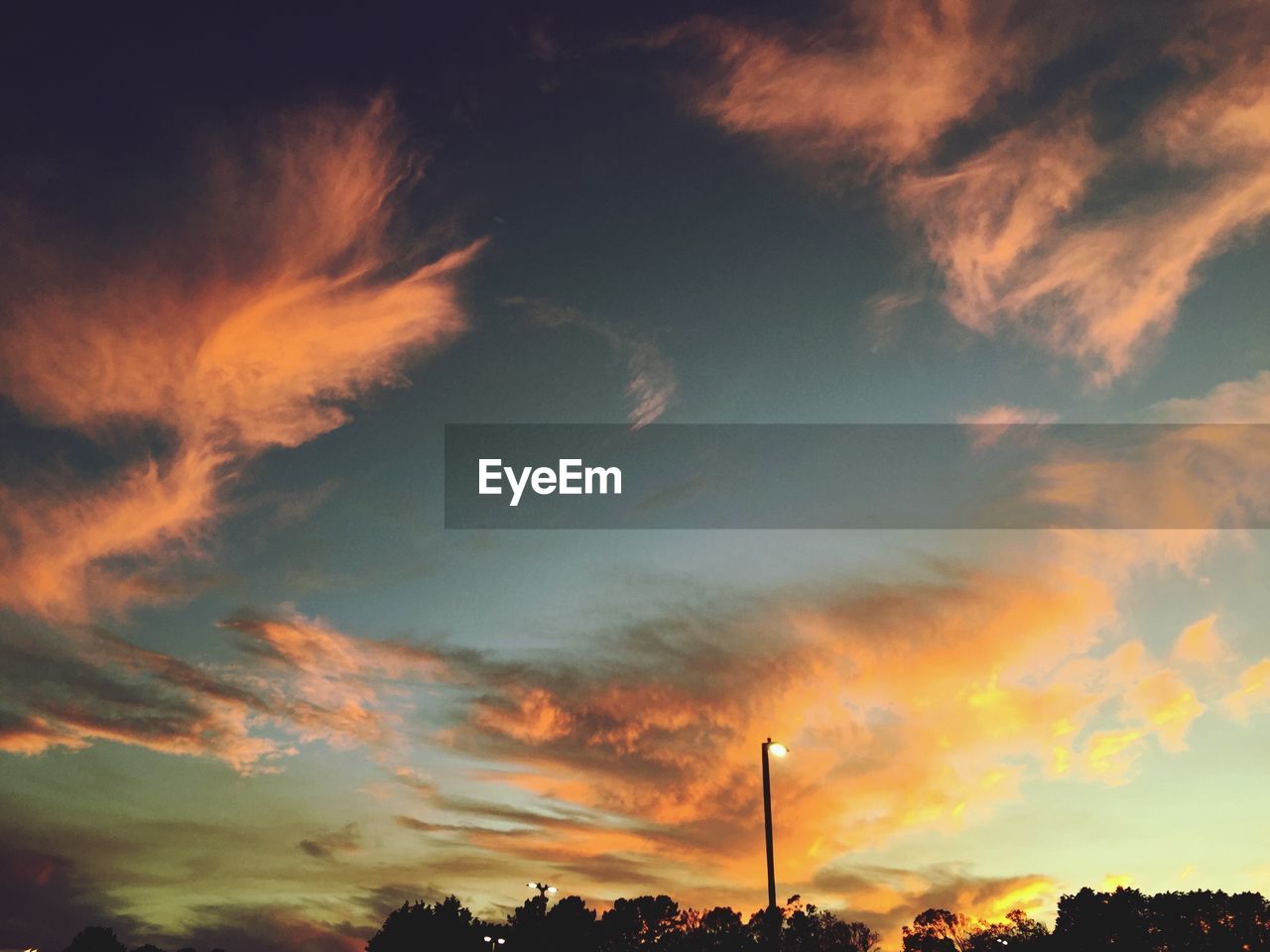 Low angle view of street light against sky during sunset