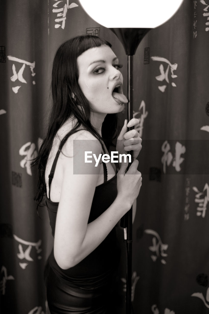 black, one person, women, adult, young adult, black and white, indoors, monochrome photography, portrait, monochrome, waist up, photo shoot, long hair, hairstyle, standing, clothing, fashion, curtain, lifestyles, holding, person, human face, looking at camera