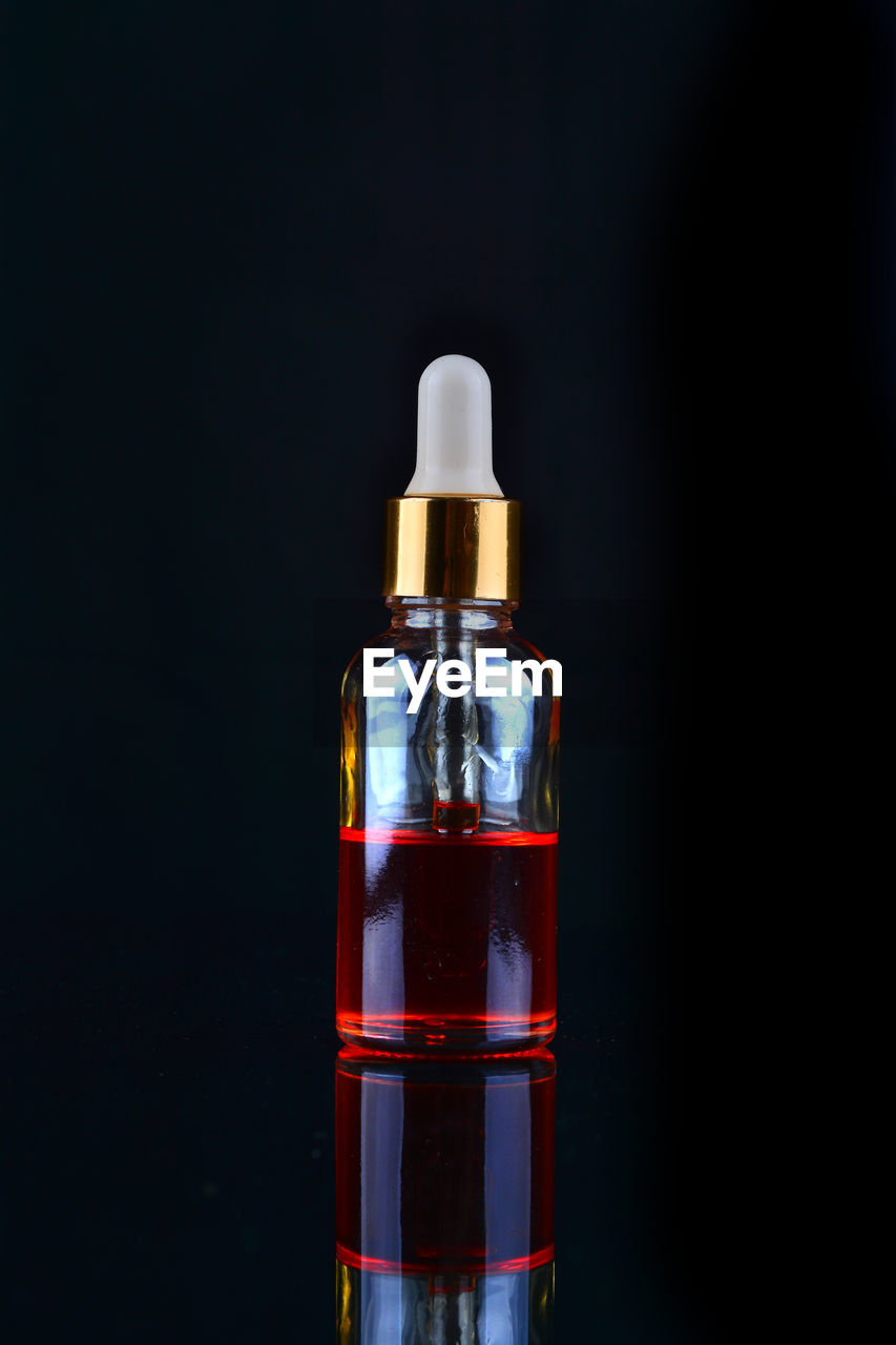 Close-up of glass bottle against black background