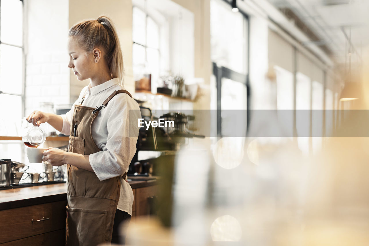 Barista preparing coffee at cafe counter