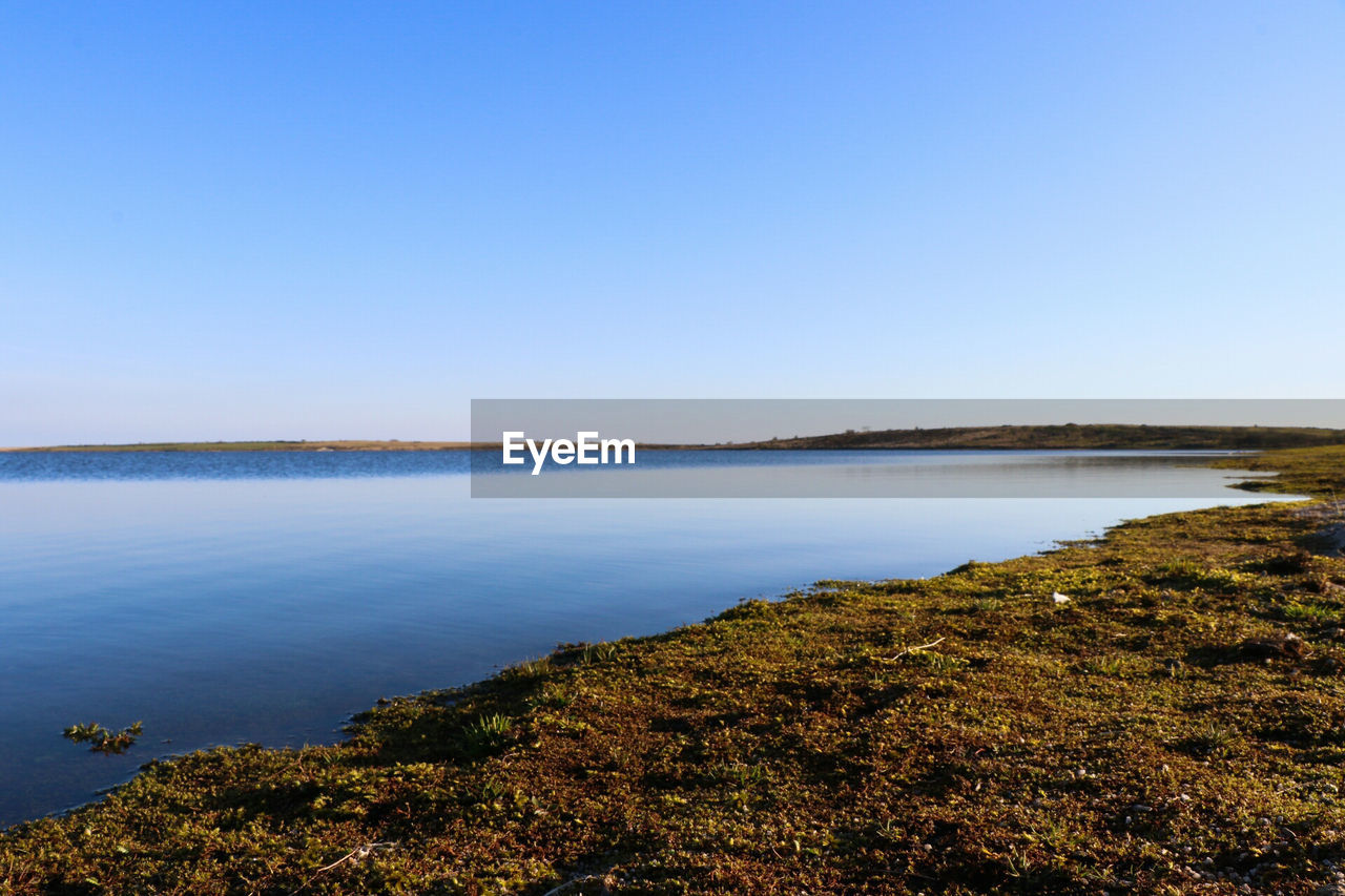 Scenic view of sea against clear blue sky