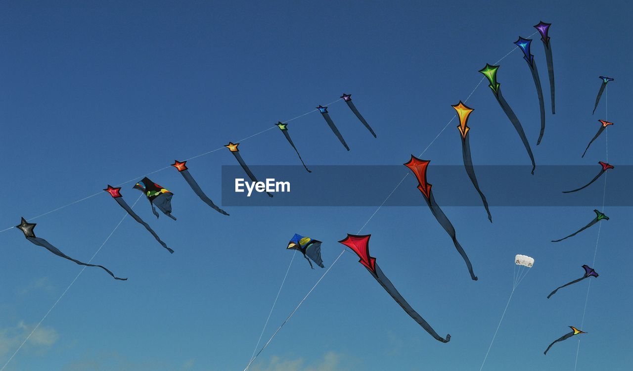 Low angle view of kites flying in sky