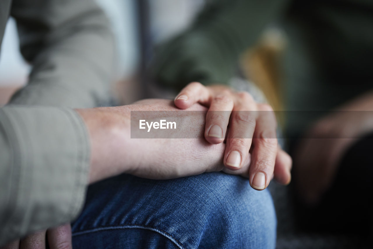 Close-up of man and woman touching hands