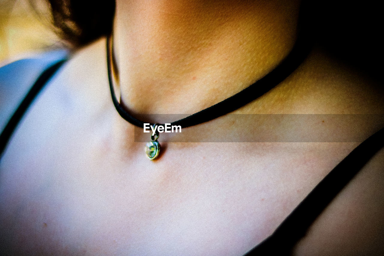 Midsection of woman wearing choker