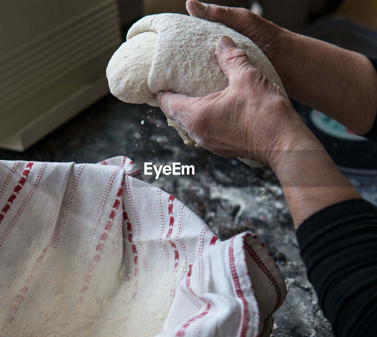 Cropped hands of woman kneading dough