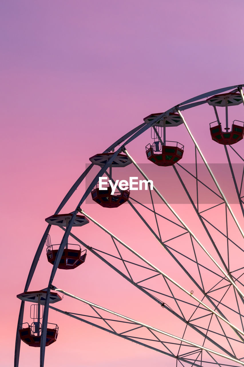 Low angle view of ferris wheel against sky during sunset