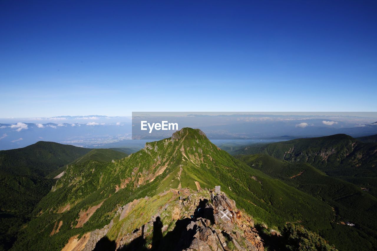 Scenic view of mountains against clear blue sky