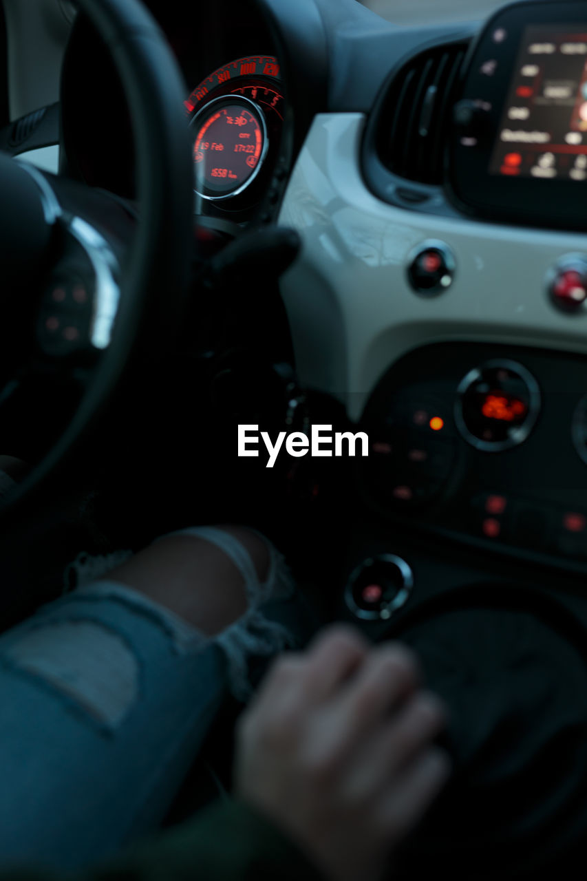 Cropped hand of woman driving car