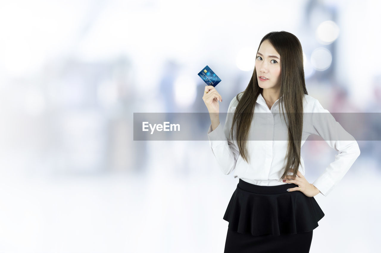 Portrait of woman with credit card standing outdoors