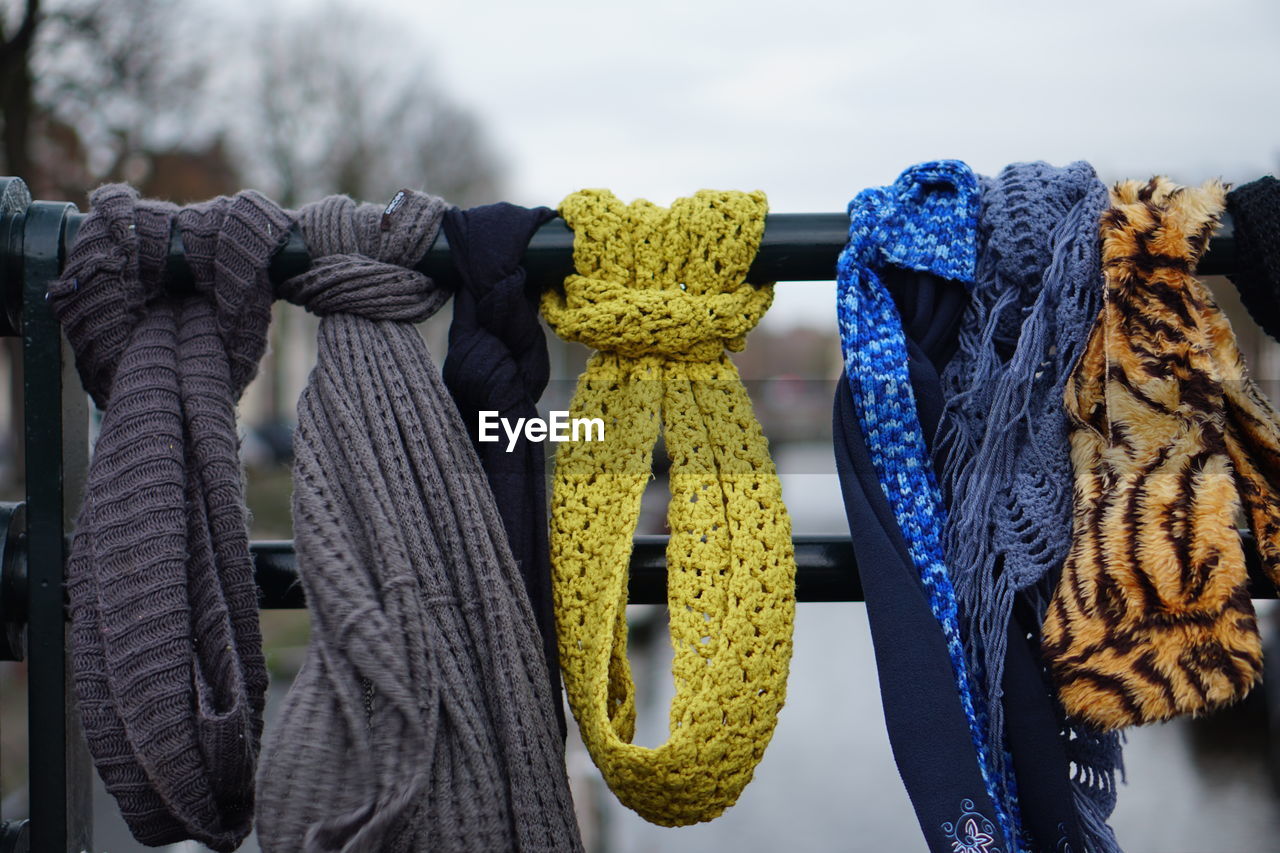 Close-up of scarves hanging on railing