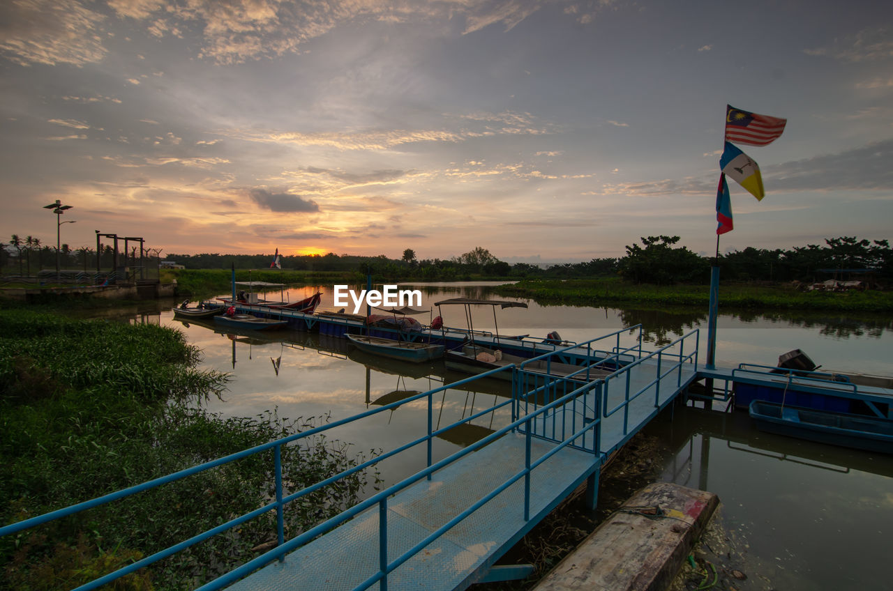 water, flag, sky, sea, reflection, nature, architecture, nautical vessel, sunset, transportation, cloud, environment, patriotism, coast, travel destinations, dock, built structure, vacation, waterway, dusk, travel, no people, evening, ship, outdoors, mode of transportation, ocean, vehicle, landscape, boat, land, bay, beauty in nature, tranquility, city, body of water, tourism, building exterior, scenics - nature, beach, shore