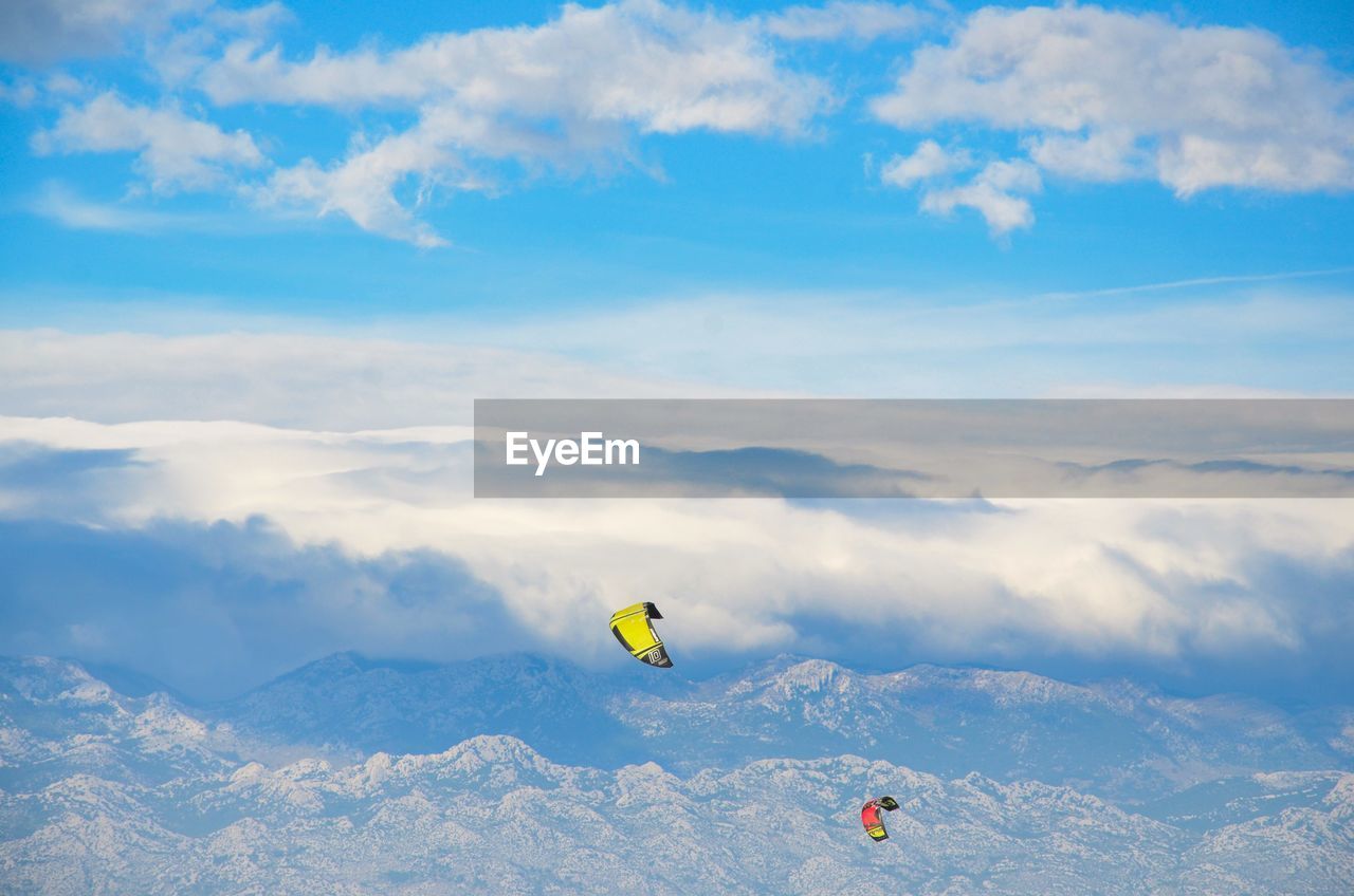 Paragliding over mountain against sky