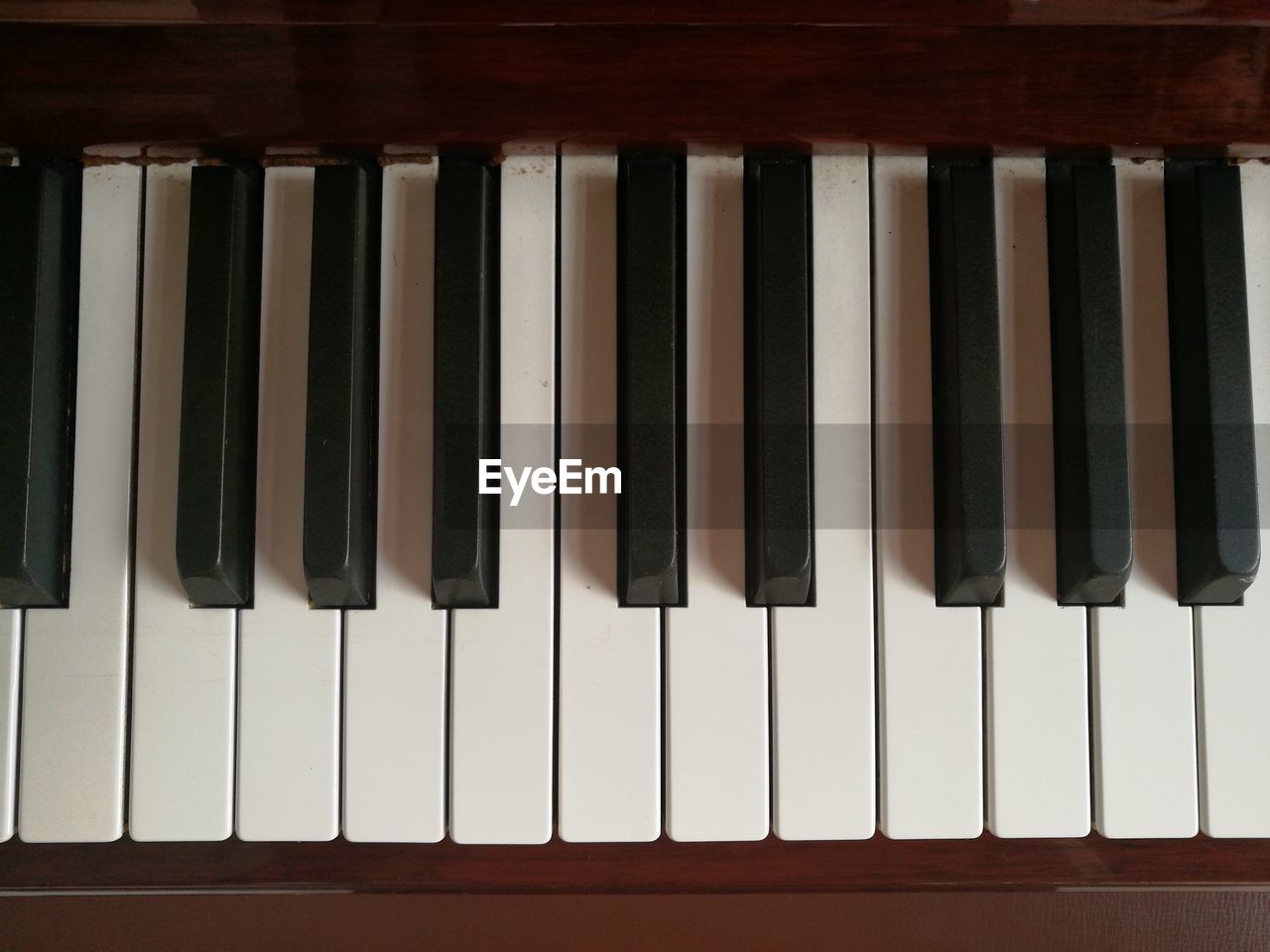 CLOSE-UP OF PIANO KEYS ON WOODEN WALL