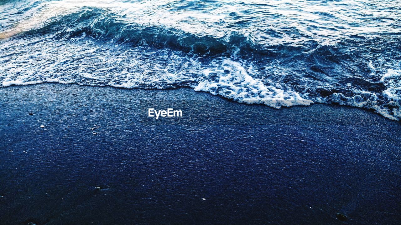 HIGH ANGLE VIEW OF WAVES ON BEACH