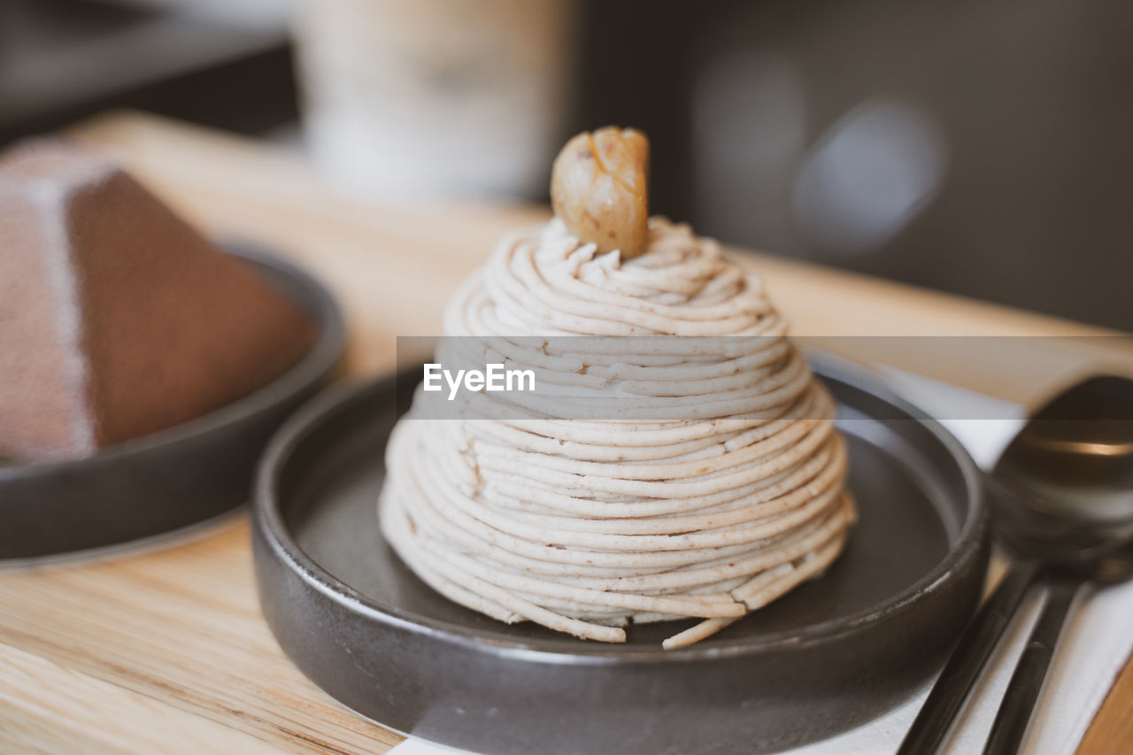 food and drink, food, dish, dessert, sweet food, icing, sweet, indoors, cake, baked, no people, kitchen utensil, freshness, cuisine, breakfast, focus on foreground, plate, wood, table, close-up, meal, eating utensil
