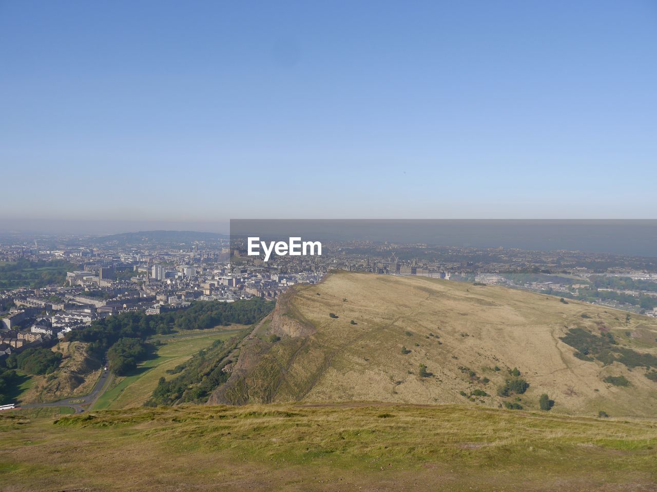 Scenic view of sea and cityscape against clear sky