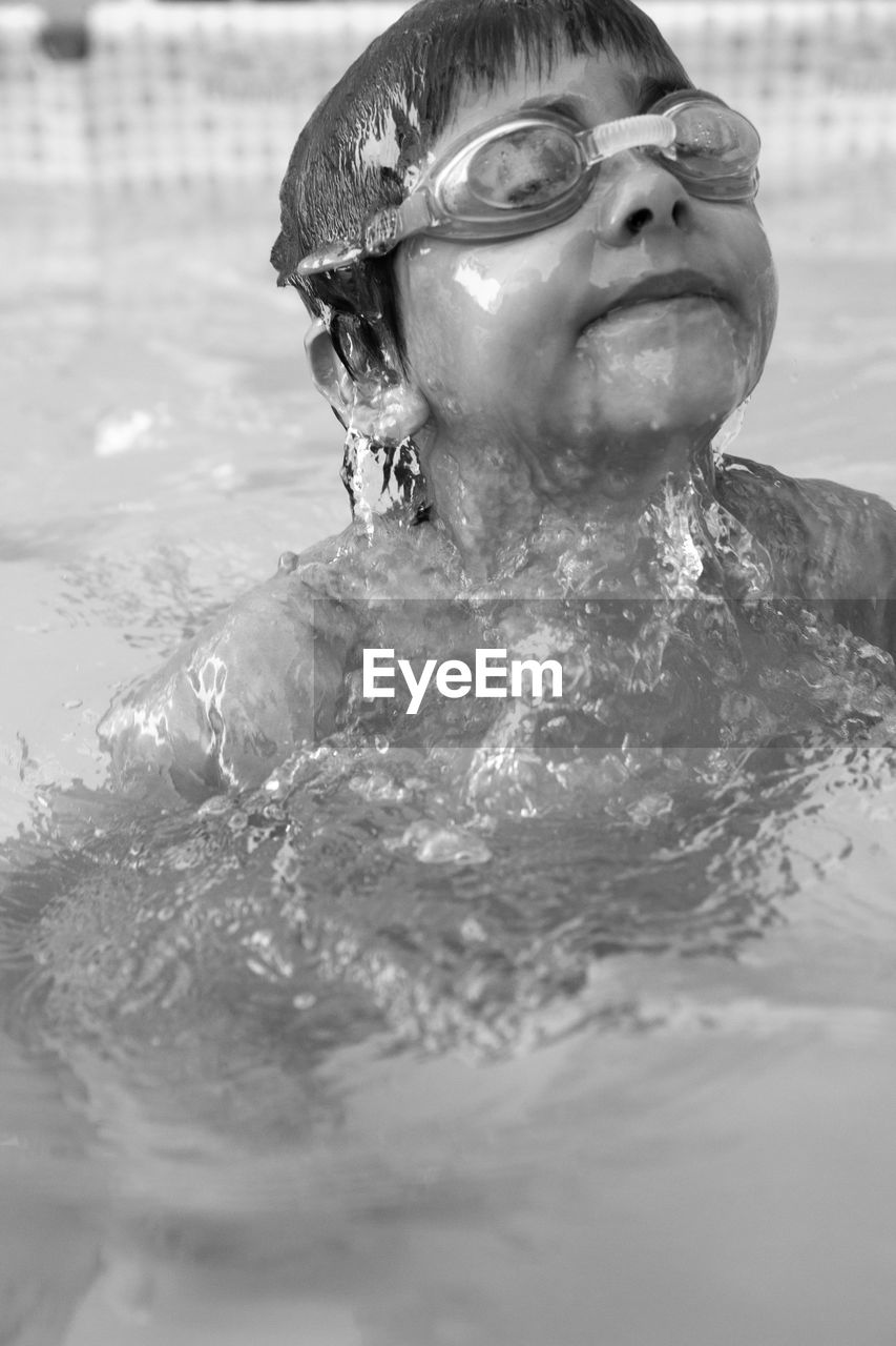 Shirtless boy swimming in pool