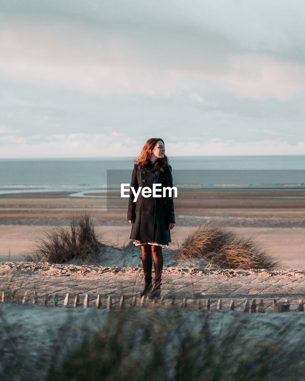 Full length of woman standing on beach against sky