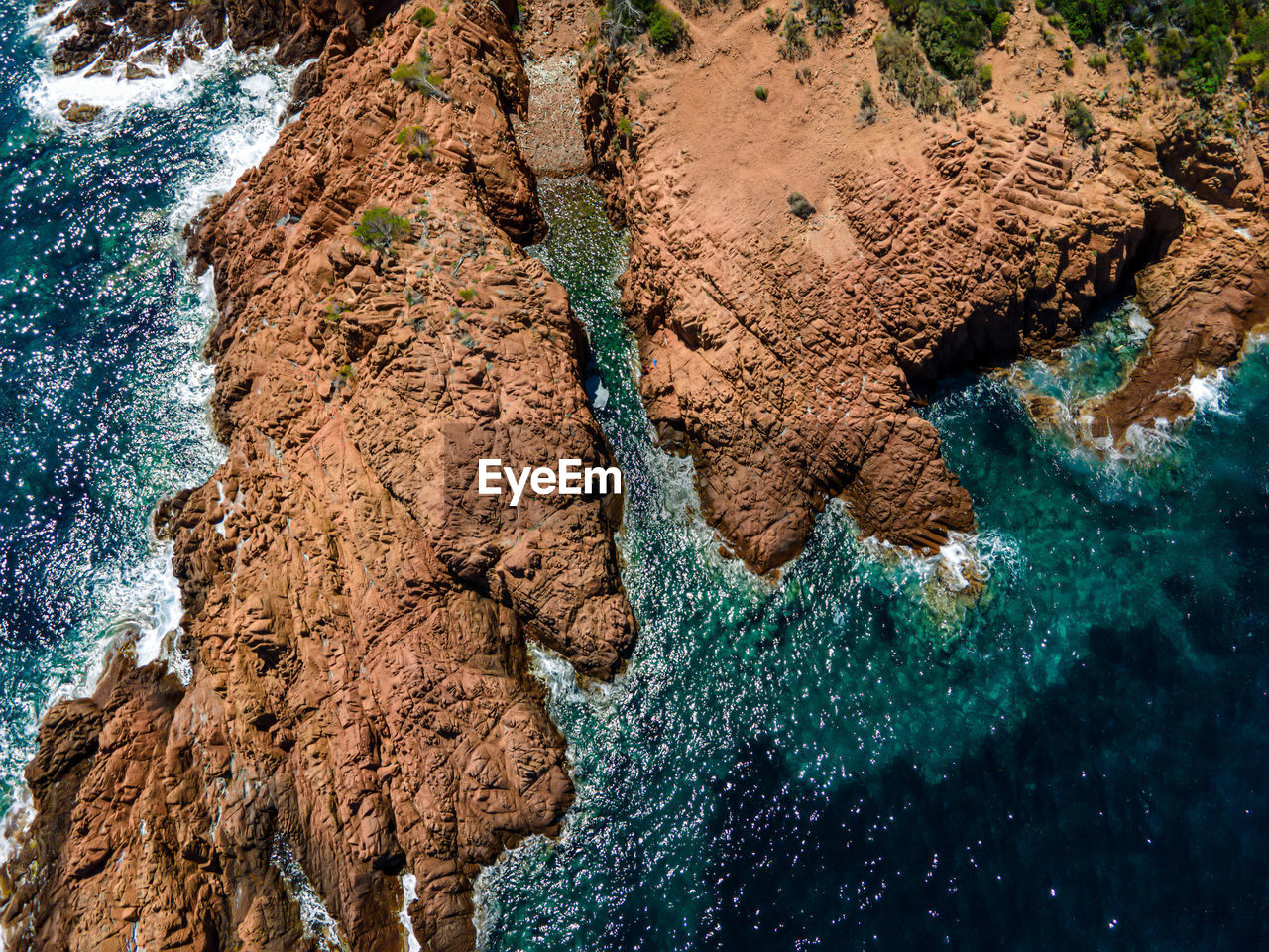 HIGH ANGLE VIEW OF ROCK FORMATIONS ON SHORE