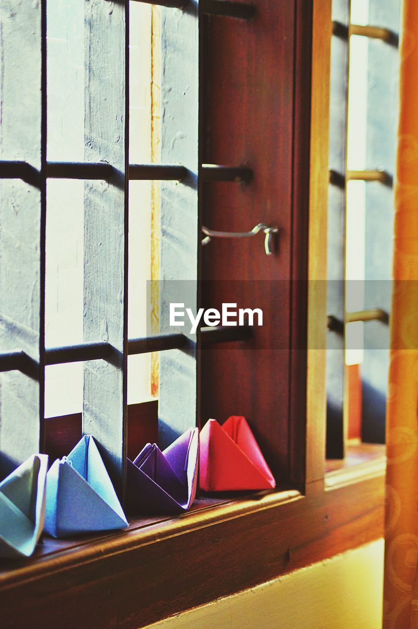 Close-up of colorful paper boats on window sill