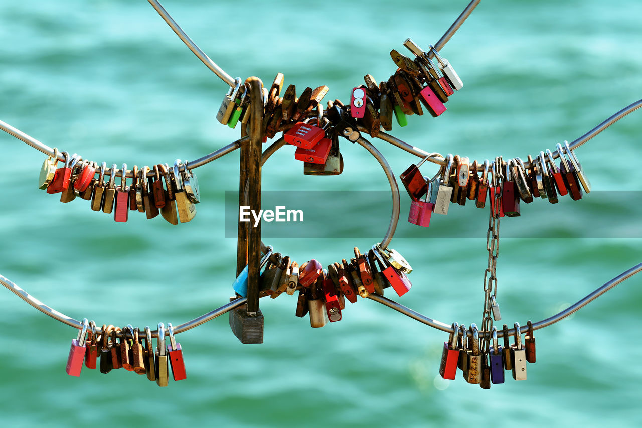 Love locks hanging on railing against sea