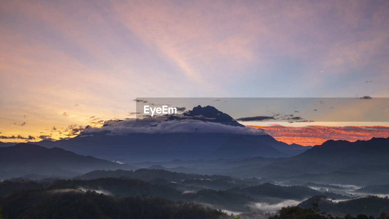 SCENIC VIEW OF MOUNTAINS AGAINST ORANGE SKY