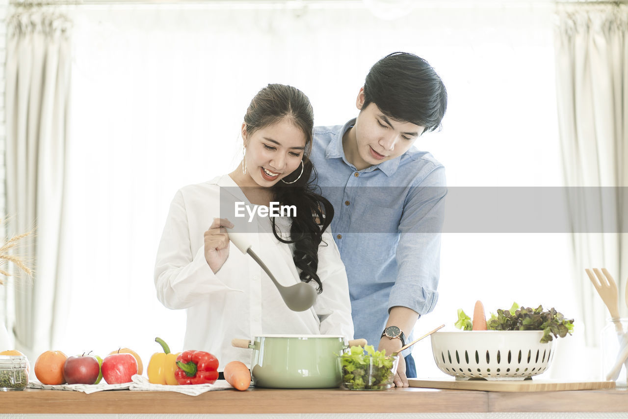 YOUNG COUPLE HOLDING FOOD AT HOME