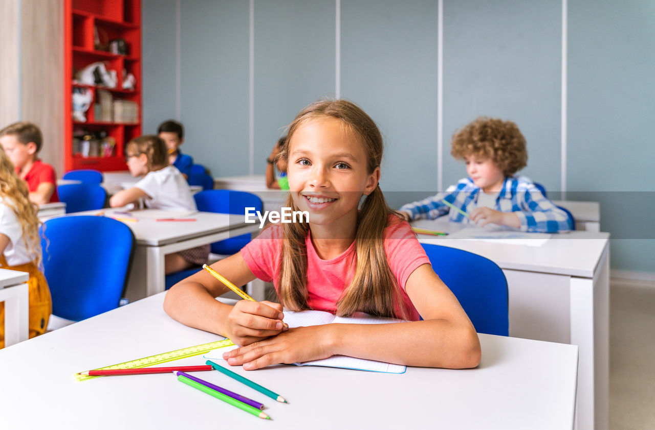 Portrait of smiling girl sitting at classroom