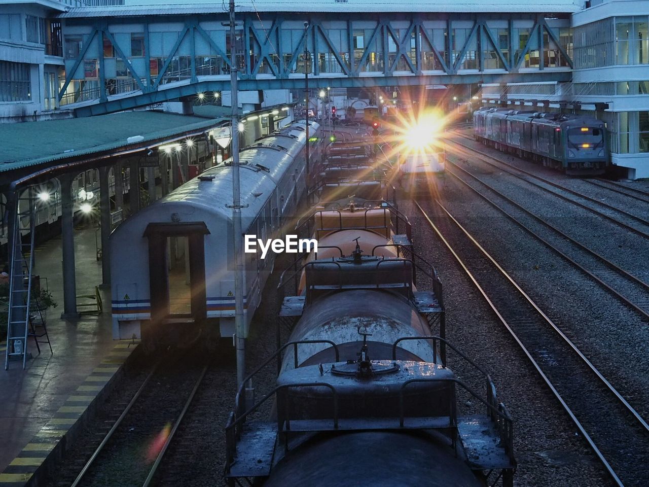 Trains on railroad station at dusk