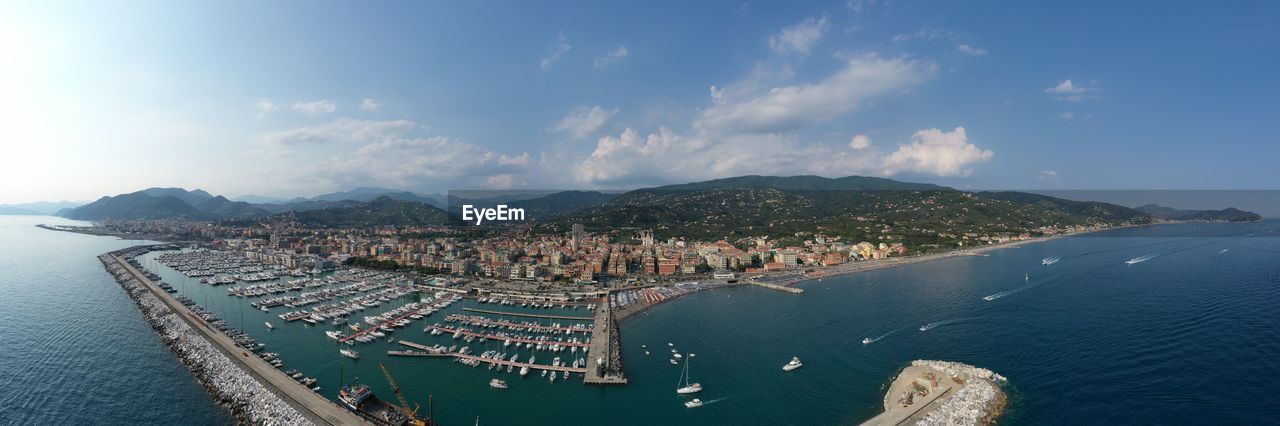 Panoramic view of city by sea against sky